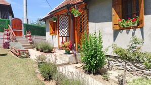 Una casa con cimientos de piedra, escalones de madera y una puerta de madera con diseño de celosía.