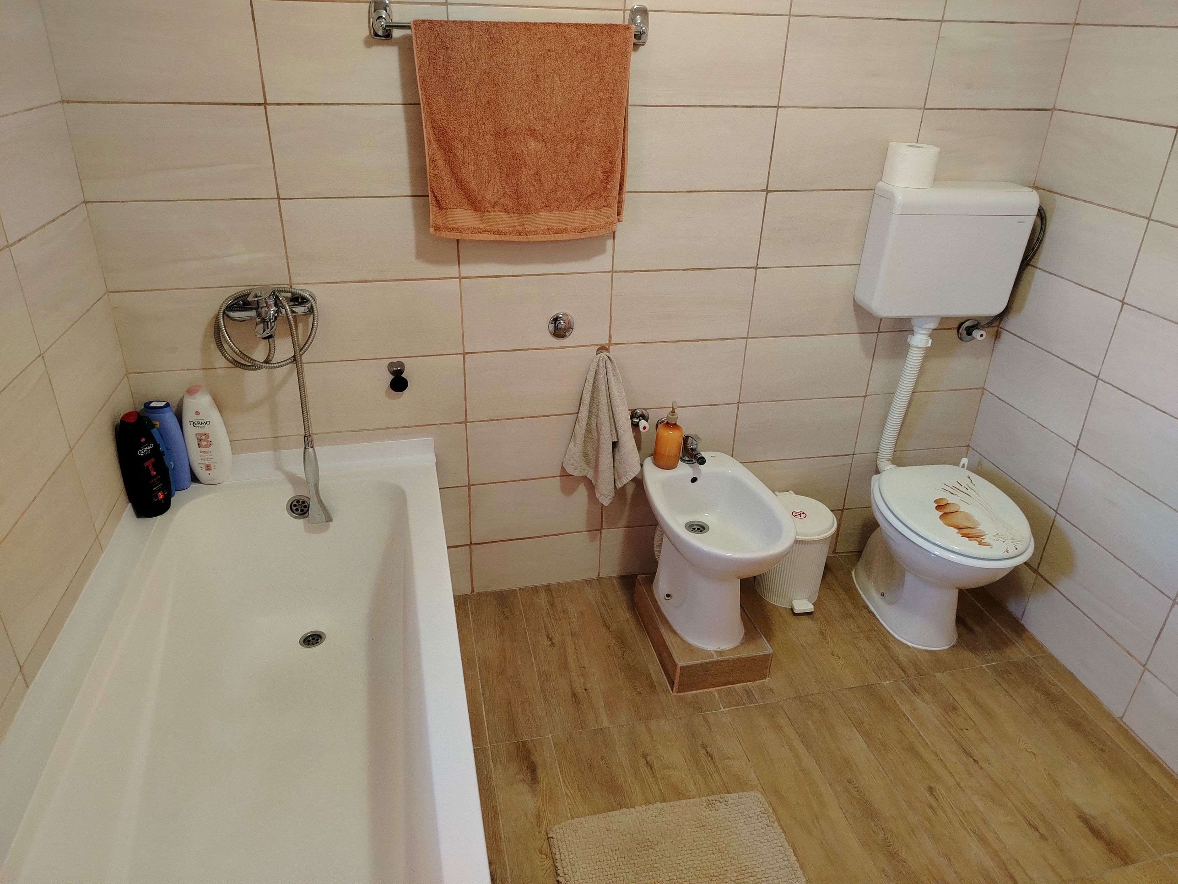 A bathroom with a bathtub, a bidet, and a toilet.