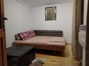 A small room with a sofa, a small table, and a framed picture on the wall.