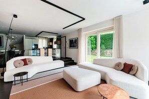 A modern living room with a sofa, ottoman, and a coffee table. - Villa Lilla (Muronico)