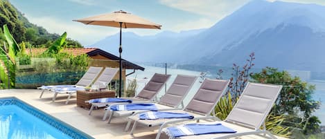 A poolside area with lounge chairs and a pergola.