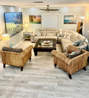 A living room with a sofa set, two wicker armchairs, a coffee table, and a ceiling fan. - 3 min walk2 bch•Heat Pool•Bbq•100”TV•On Ocean Blvd (Fort Lauderdale)