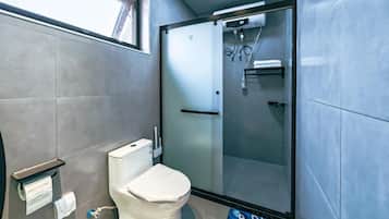 Un baño con inodoro, ducha y puerta de vidrio.