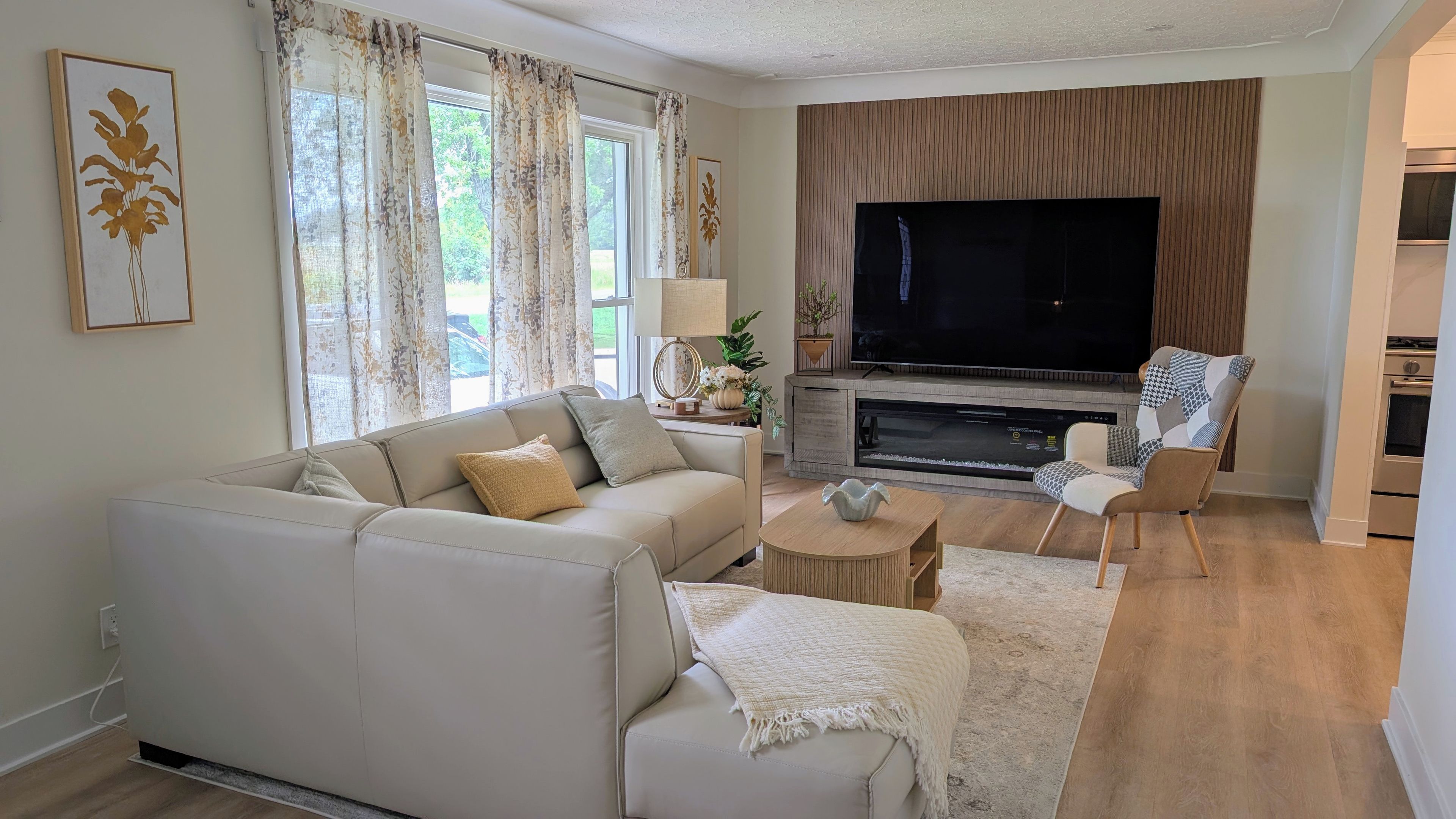 A living room with a sofa, armchair, and a television.