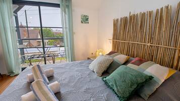 A bedroom with a bed, pillows, a window with curtains, and a view of the outside.