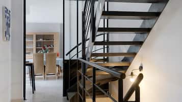 Ein modernes Interieur mit Treppe, Essbereich und Bücherregal.