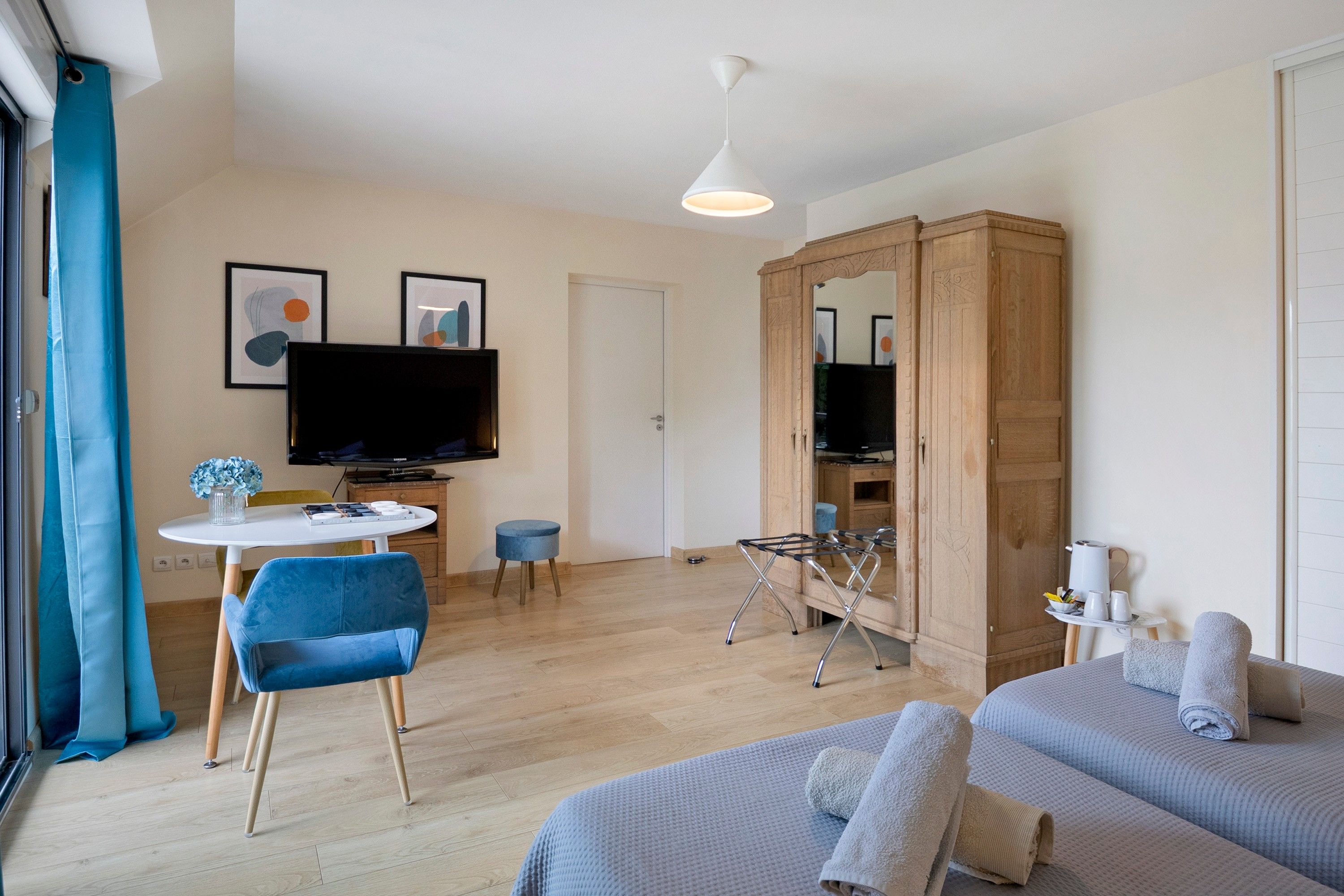 Un salon moderne doté d’un téléviseur à écran plat, d’un coin repas et d’une armoire.