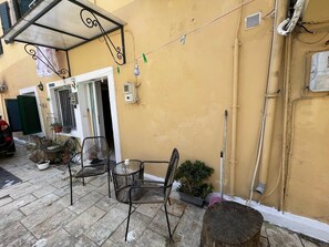 Eine Terrasse mit Sitzgelegenheit, einem Holztisch und Stühlen.