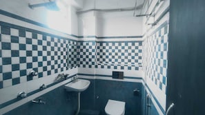 Ein Badezimmer mit Schachbrettfliesen, einem Waschbecken, einer Toilette und einem Spiegel.