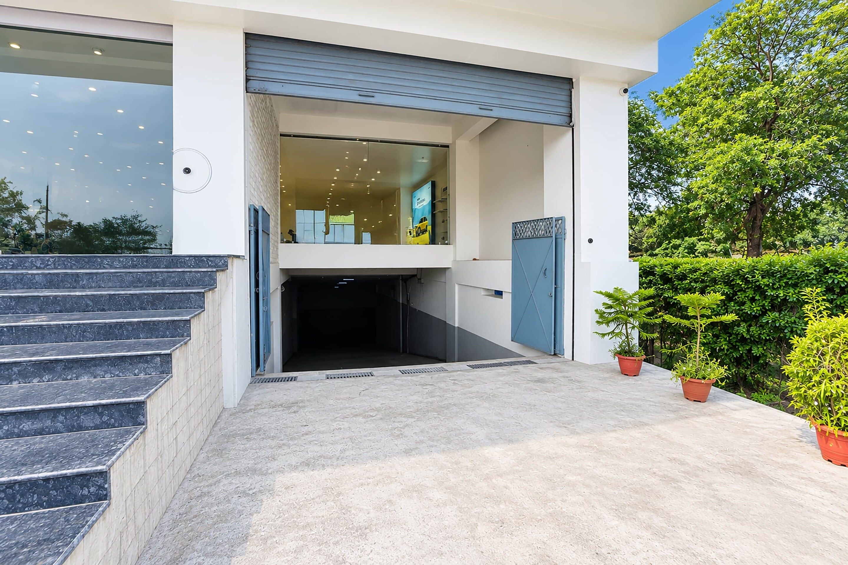 A modern building entrance with a set of stairs leading up to a garage door.