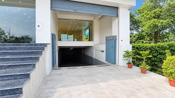 A modern building entrance with a set of stairs leading up to a garage door.