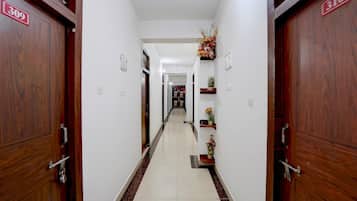 A hotel corridor with wooden doors, numbered 309 and 310, and a tiled floor.