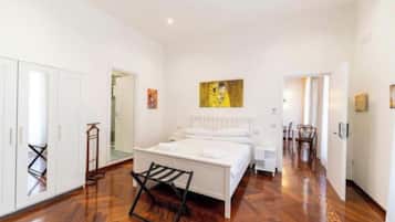 A bedroom with a bed, a chair, and a painting on the wall.