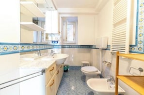 A bathroom with a sink, toilet, bidet, and a mirror. - Marina Rooms (Napoli)