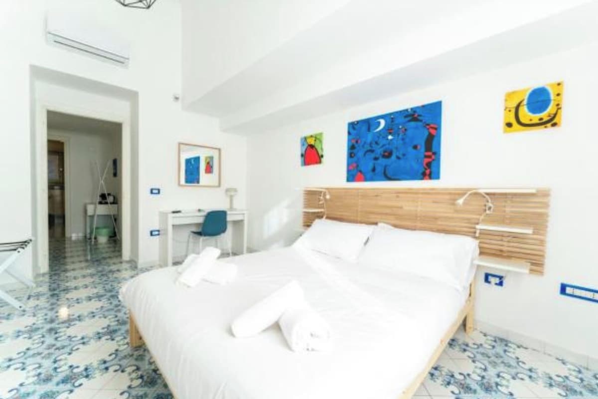 A hotel room with a bed, a desk, and a chair.
