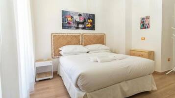 Ein Schlafzimmer mit einem Bett, einem Nachttisch und einem Wandbild.
