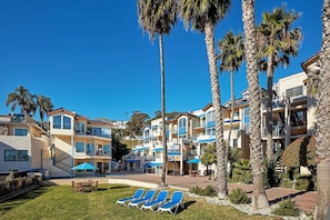 A resort with multiple-story buildings, outdoor seating areas, and palm trees. - Seaport Village Inn, Avalon | 2 Ocean View Suites | 1 Queen Bed (Avalon)