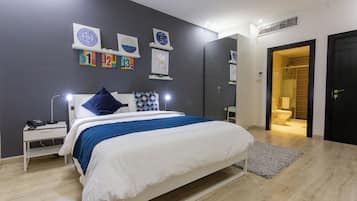 A modern bedroom with a bed, bedside table, and wall art.
