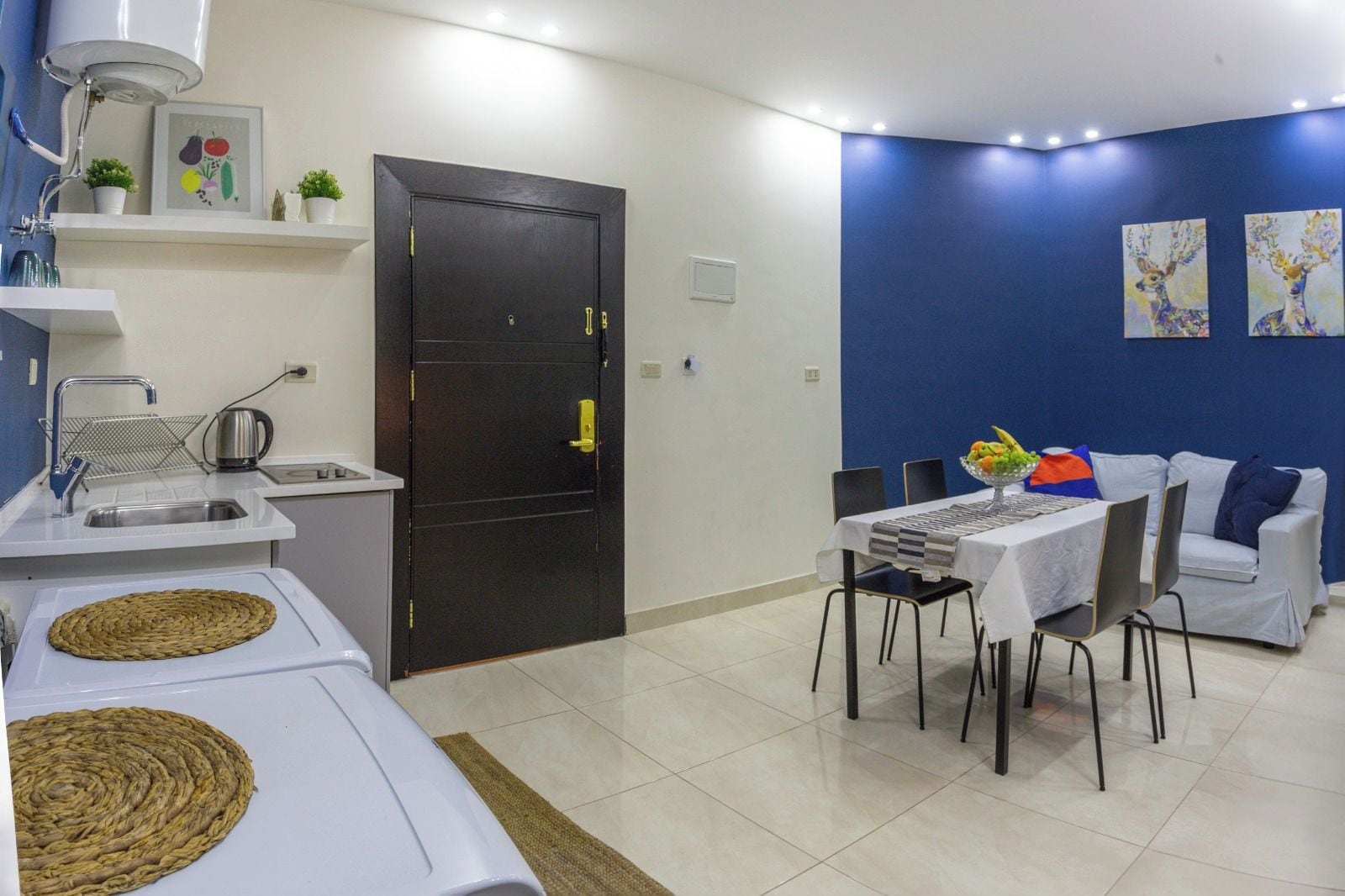 A compact living space with a kitchenette, a dining area, and a sofa.