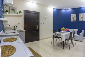 A compact living space with a kitchenette, a dining area, and a sofa.