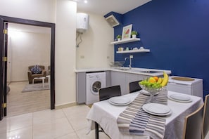 Un espace de vie compact comprenant un coin repas, un lave-linge et une petite cuisine.