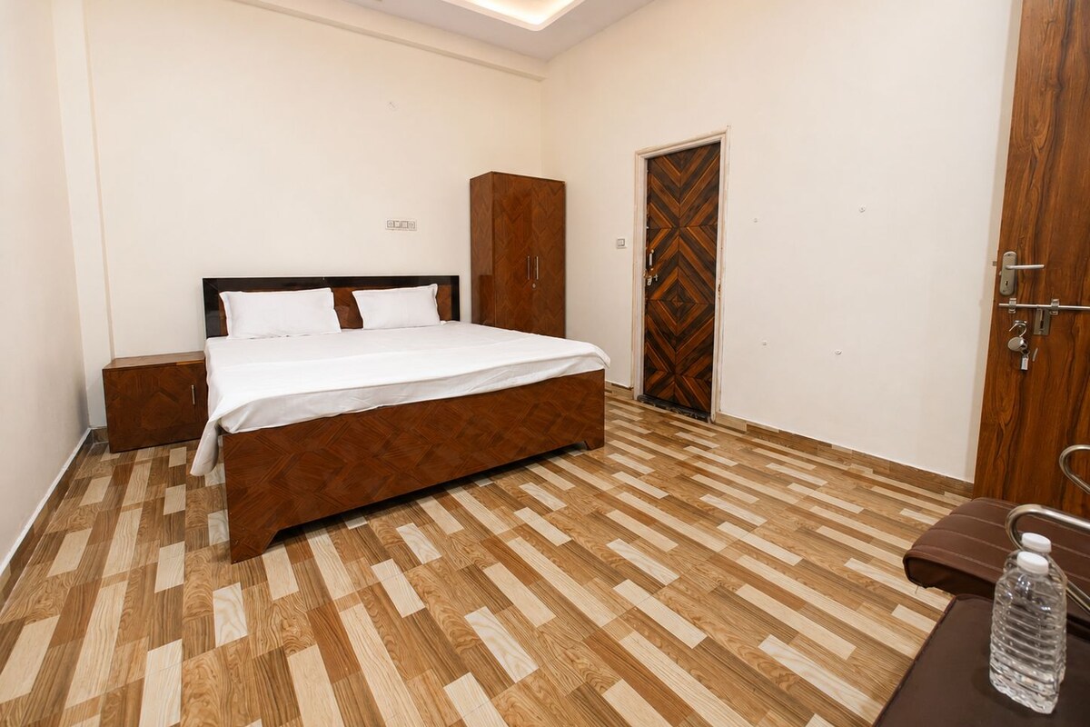A bedroom with a bed, wooden wardrobe, and a door with a geometric pattern.