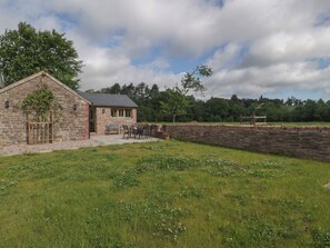 A stone building with a patio and outdoor seating. - Ynys (Abergavenny)