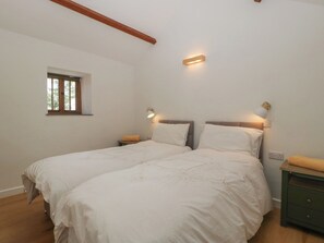 A bedroom with two beds, a window, and bedside lamps. - Ynys (Abergavenny)