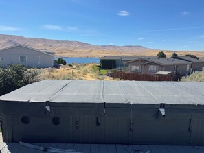 A residential area with houses, a wooden deck, and a view of mountains and a lake. - Cozy Beach Place Cottage 3-bedroom house with AC in charming Desert Aire (Mattawa)
