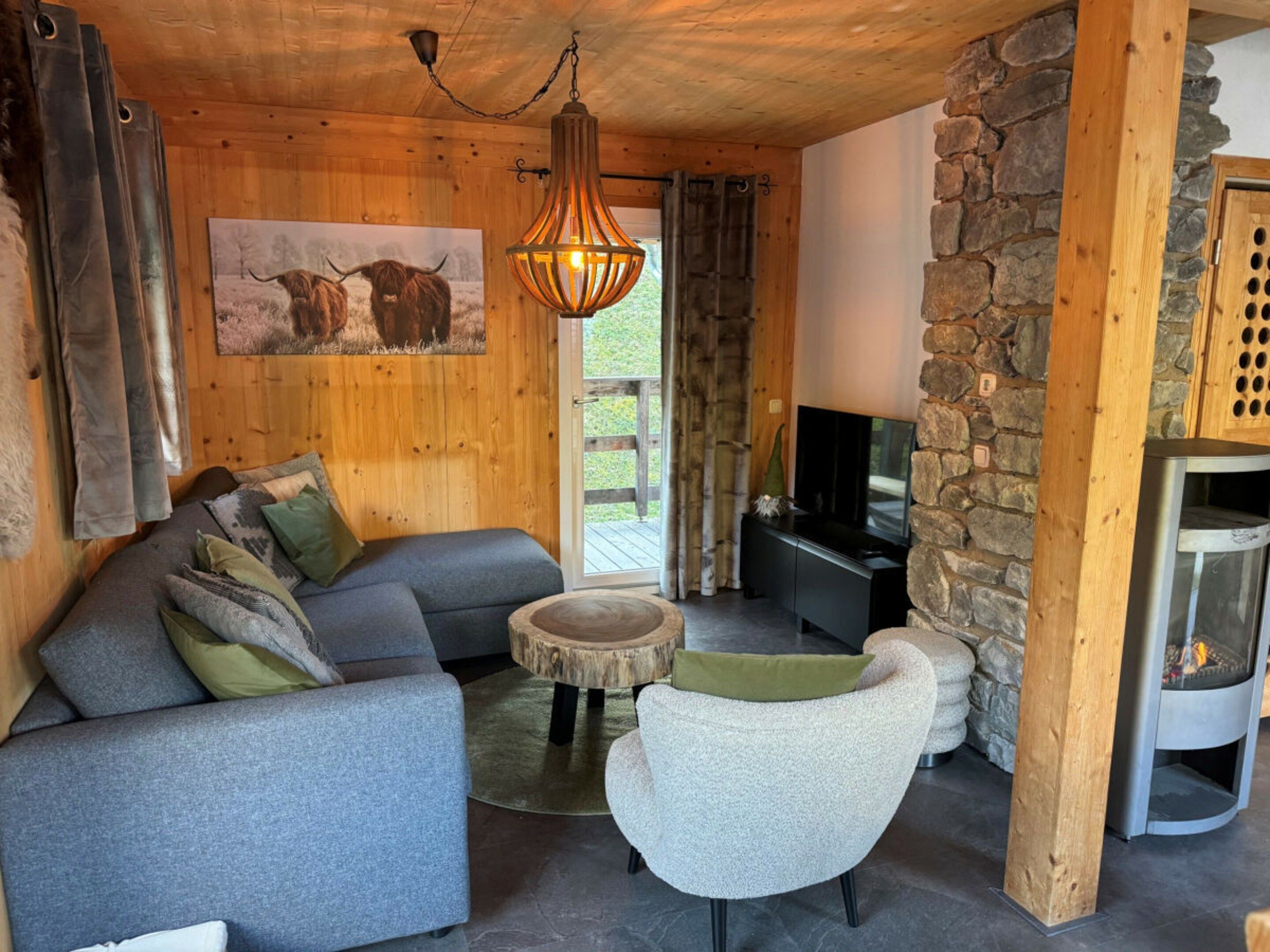 Un salon confortable avec un canapé, un fauteuil et un téléviseur.