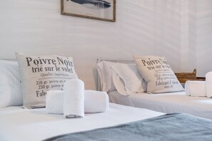 Ein Hotelzimmer mit zwei Betten, jedes mit einem Kopfkissen, das Text über die hochwertigen Wollprodukte des Hotels zeigt.