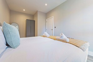 A hotel room with a bed, a wardrobe, and a door. - Gym | Coworking | City Centre 2BR | StayCozy (Birmingham)