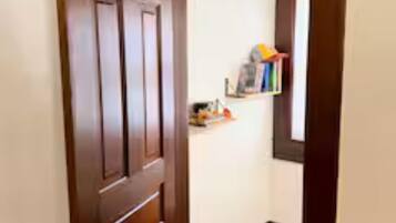 A wooden door leading to a hallway with a wooden floor.
