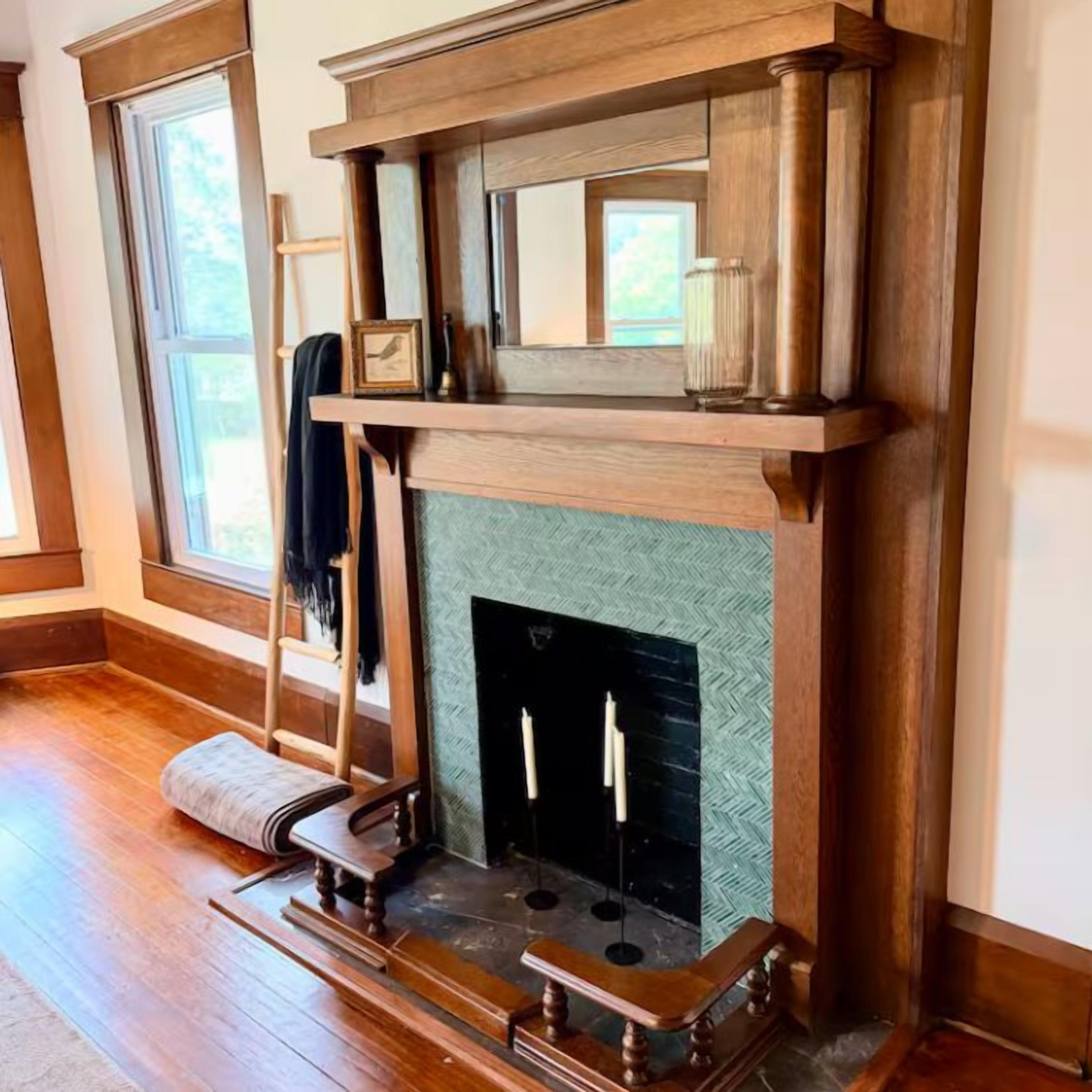 A room with a fireplace, a ladder, and a bench.