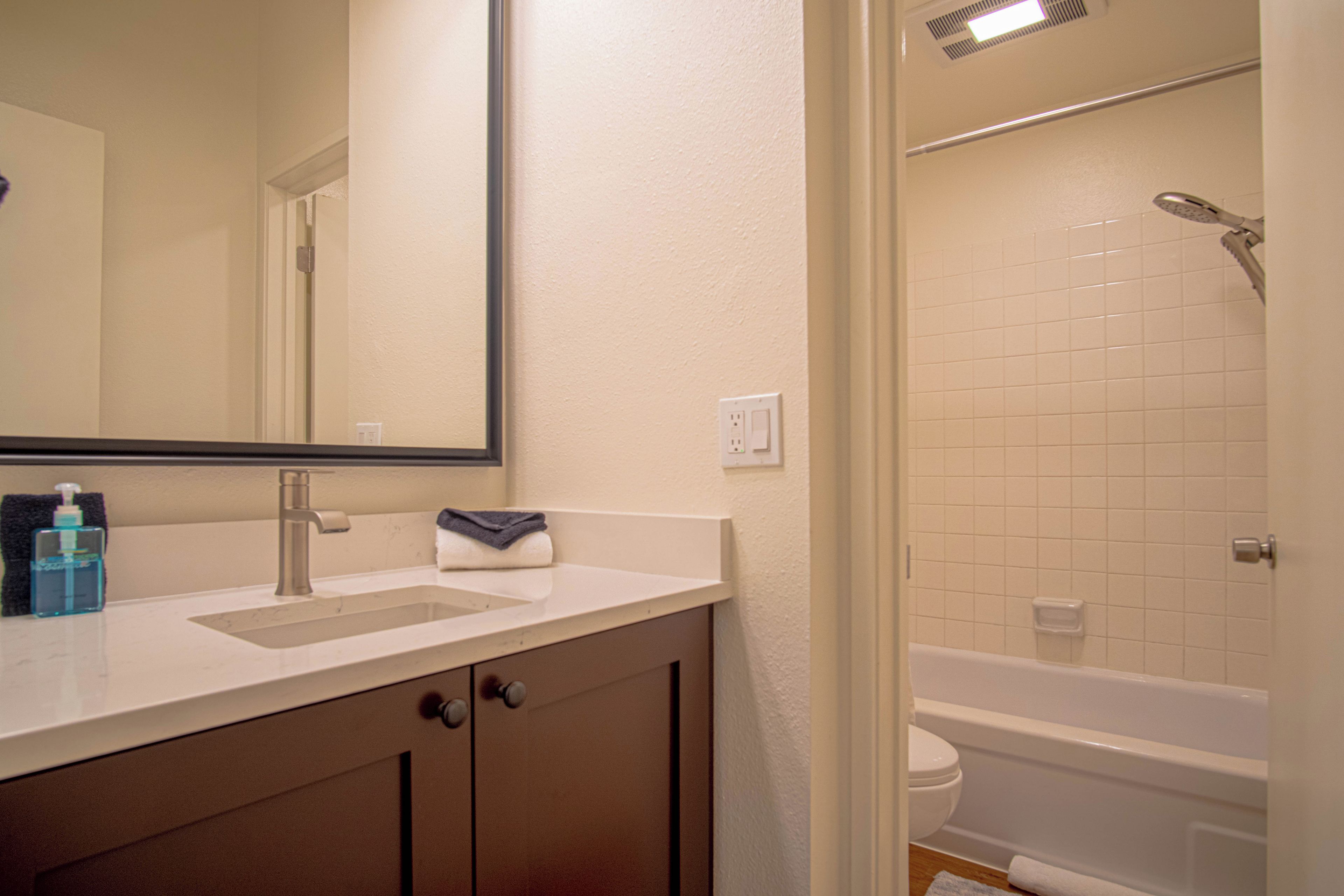 Une salle de bain équipée d’un lavabo, d’un miroir et d’un espace douche.