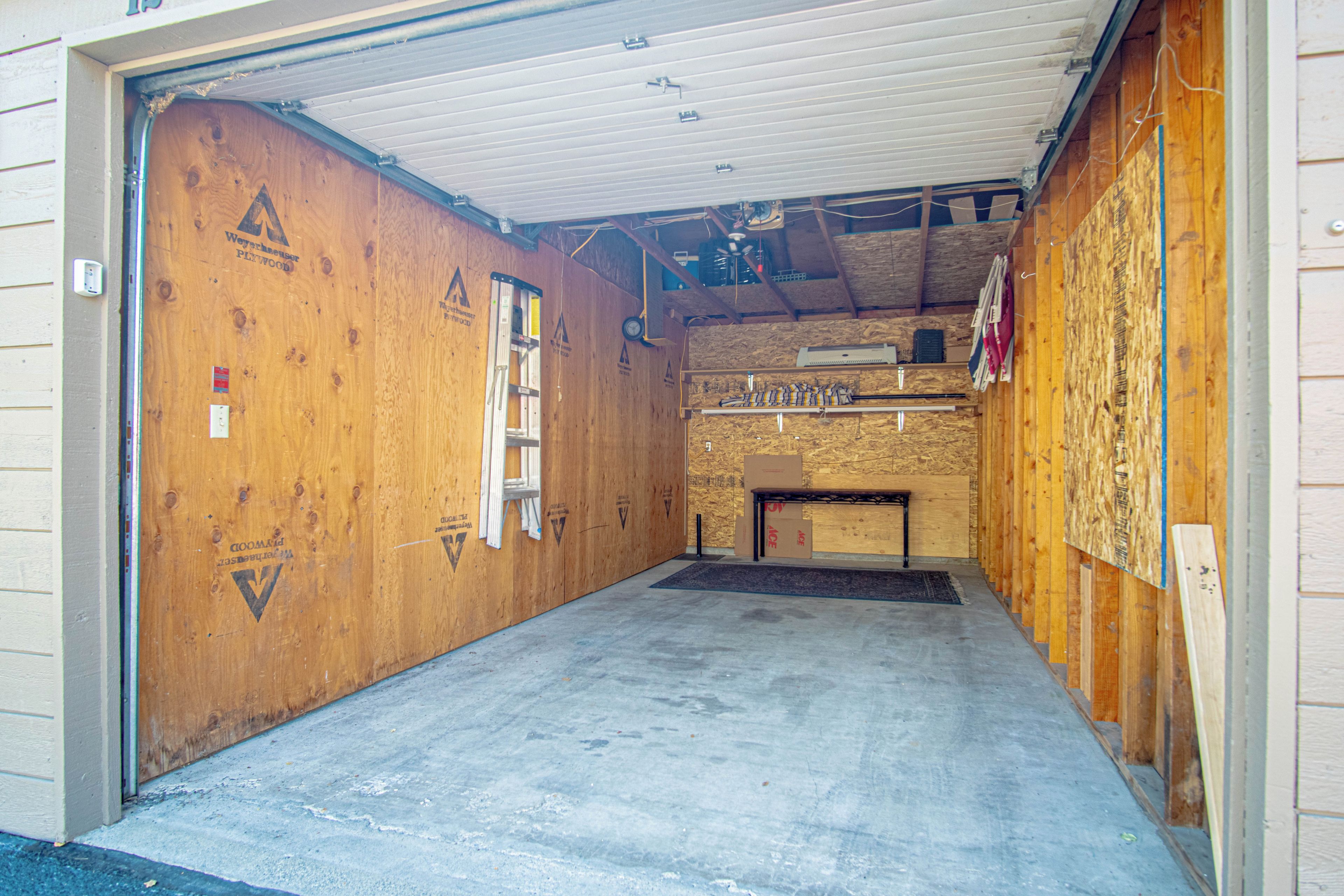 Ein Zimmer im Bau mit freiliegenden Holzwänden, einem Betonboden und Baumaterialien.