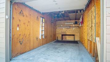 Ein Zimmer im Bau mit freiliegenden Holzwänden, einem Betonboden und Baumaterialien.