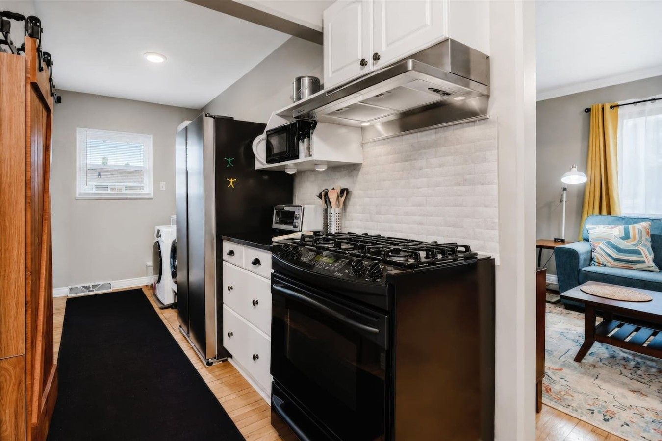 A compact kitchen with a gas stove, microwave, and a built-in oven.