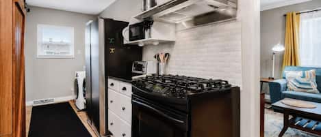 A compact kitchen with a gas stove, microwave, and a built-in oven.