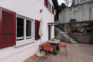A patio area with a table and chairs, a covered seating area, and a staircase leading to a lower level. - Casa 2 – Modern Vacation Rental on Lake Maggiore (Vairano)