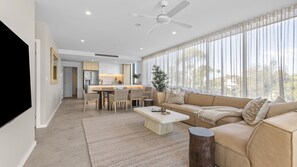 Ein modernes Wohnzimmer mit Sofa, Couchtisch und Essbereich.