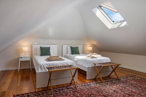 Una habitació amb dos llits, un fanal i una catifa amb dibuixos.