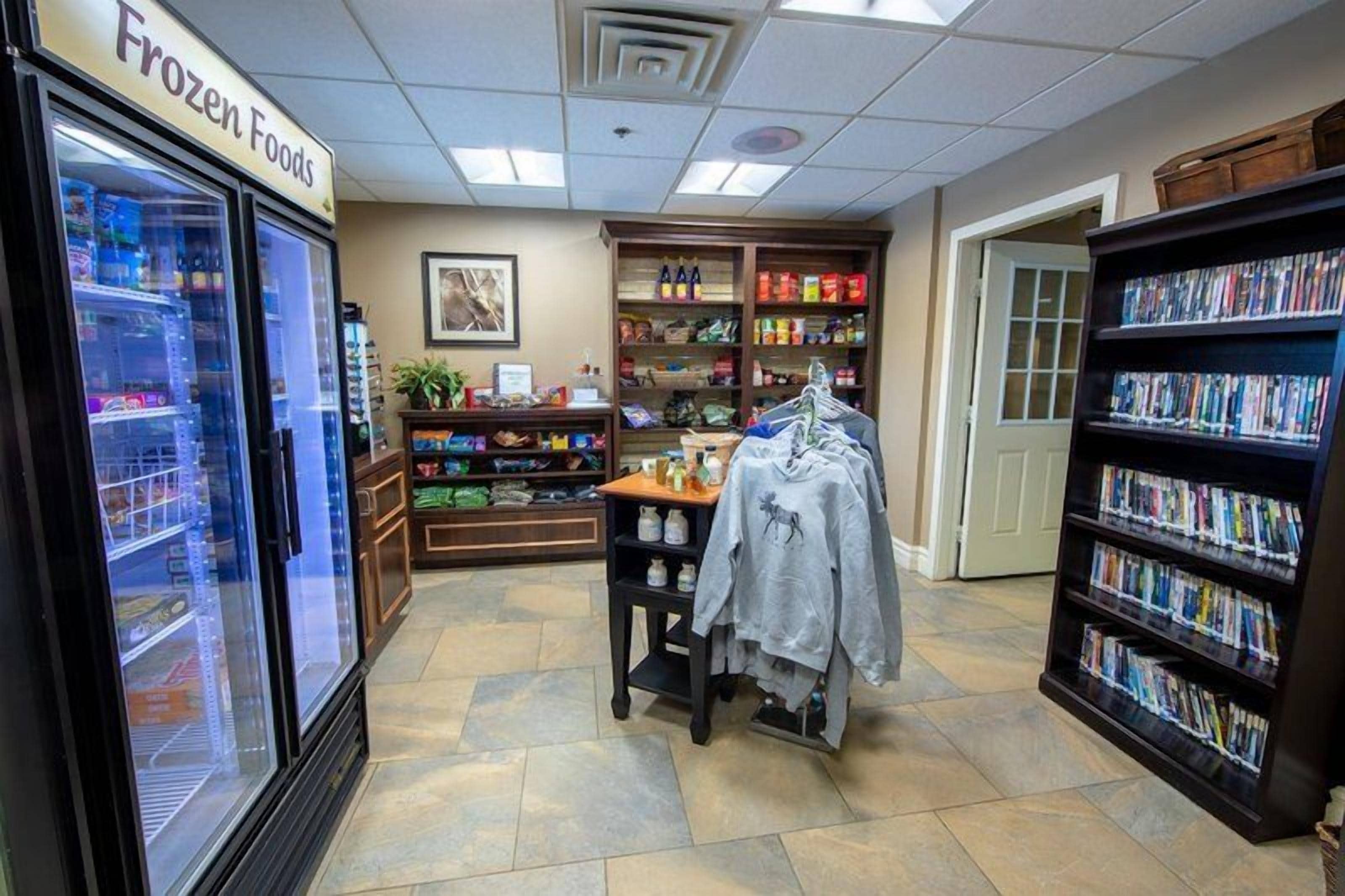 Interno di un negozio di alimentari con prodotti surgelati, un'asta per abiti e una libreria.
