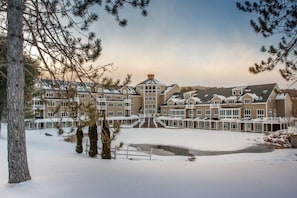 A large hotel with multiple buildings, a central courtyard, and a small pond.