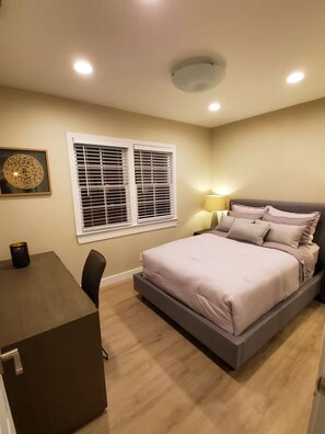 A bedroom with a bed, bedside table, lamp, and window blinds. - Bright 2BR with Chef's Kitchen near Sony Studios (Culver City)