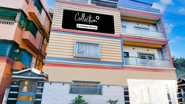 A multi-story building with a sign that reads 'Collection Company Service.' - Deluxe Shyam Bazar Guest House (Kolkata)