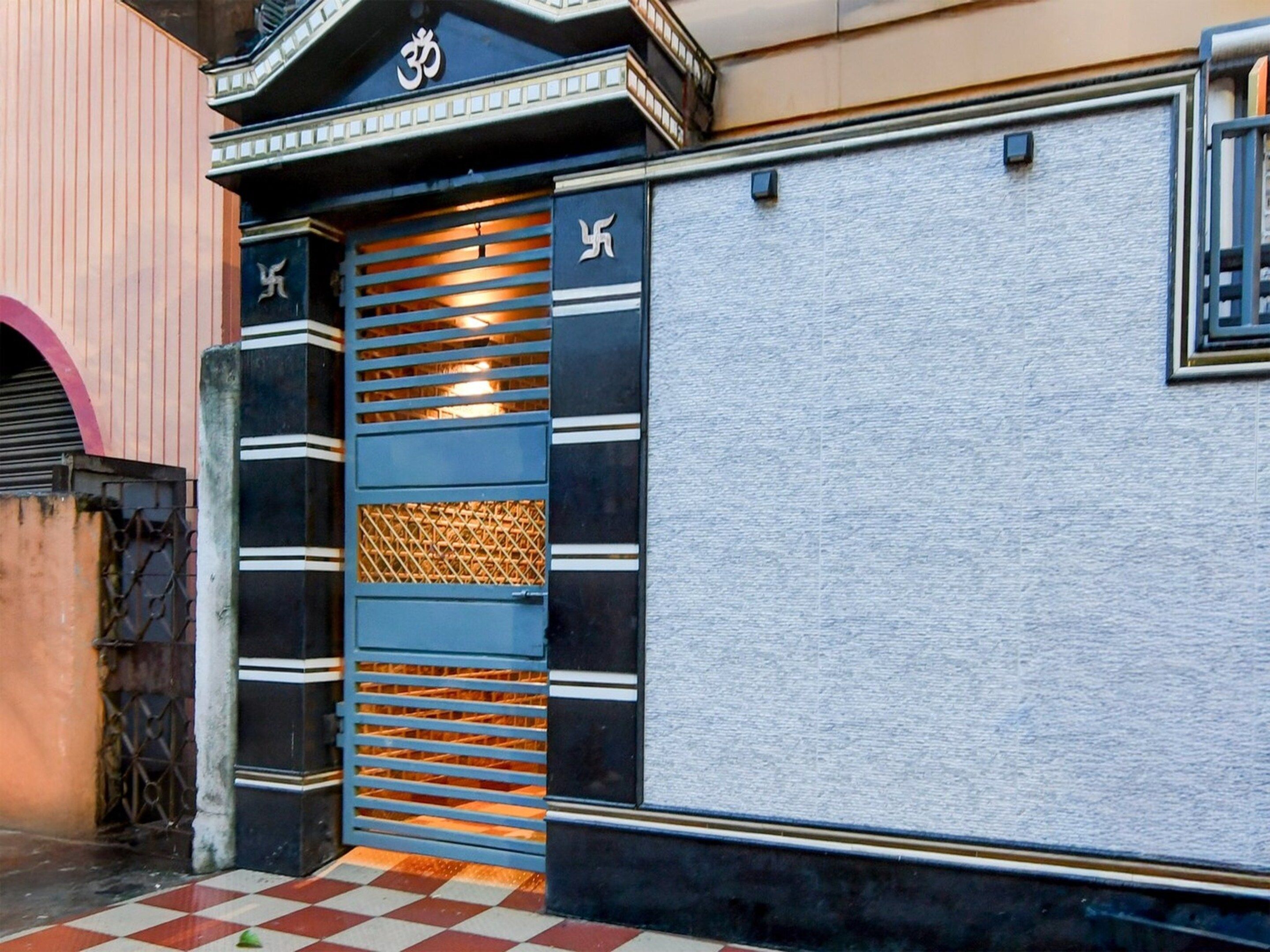 A building entrance with a decorative gate featuring horizontal slats and a textured panel.