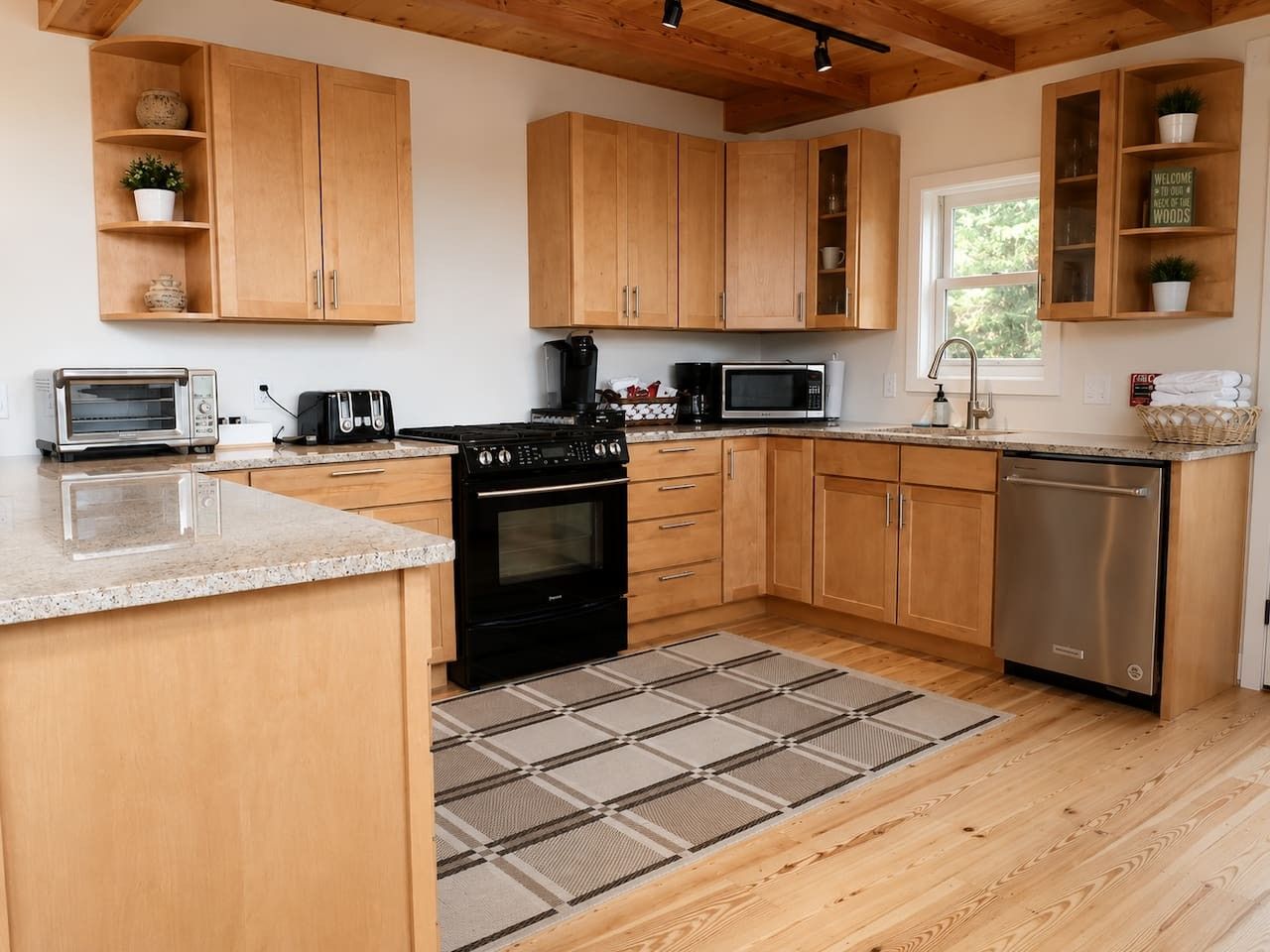 A kitchen with wooden cabinets, a stove, a microwave, and a dishwasher.