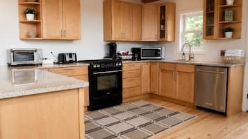A kitchen with wooden cabinets, a stove, a microwave, and a dishwasher.
