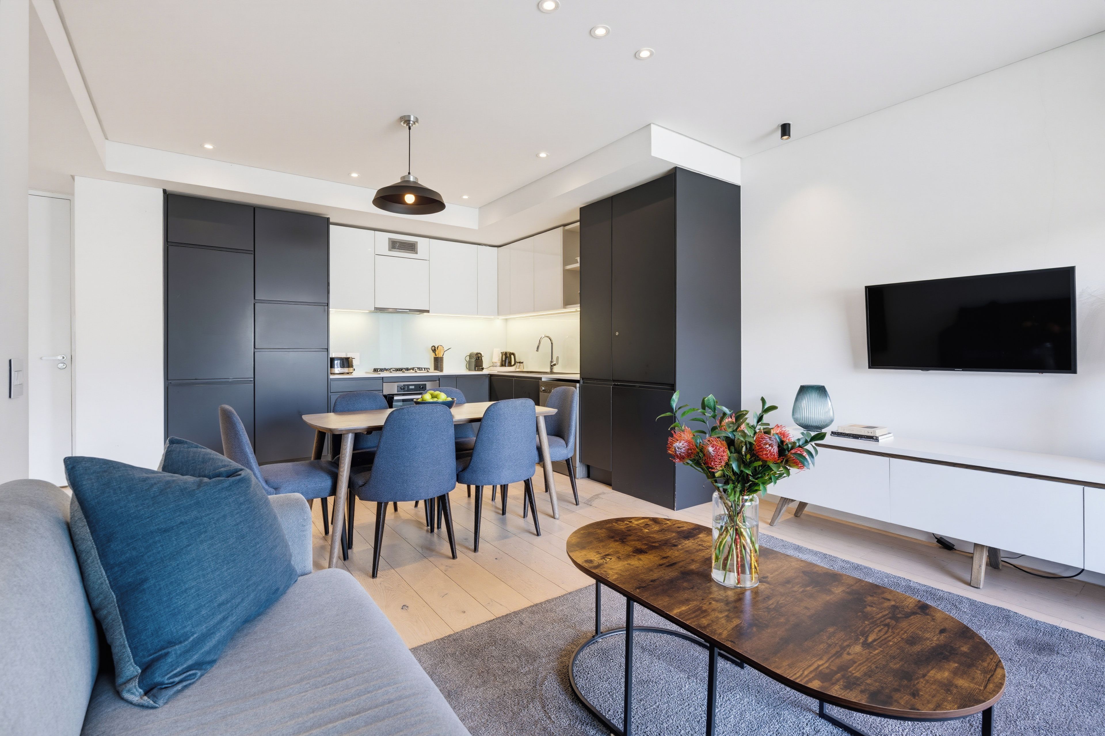 Un salon moderne avec un canapé, une table basse et un téléviseur à écran plat.